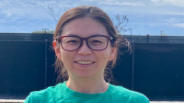 Mandy, OC Animal Care volunteer of the month wearing a green shirt that reads "Adopt Today"